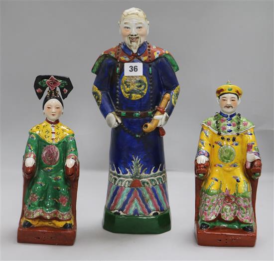 A pair of Chinese polychrome pottery figures, seated Emperor and Empress, and another of an official (one a.f.)